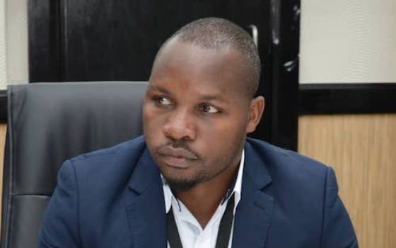 Boniface Chibwana, coordinator for the Catholic Commission for Justice and Peace of Malawi's bishop's conference sitting at desk